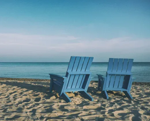 Two beach chairs facing the ocean — a relaxed retirement